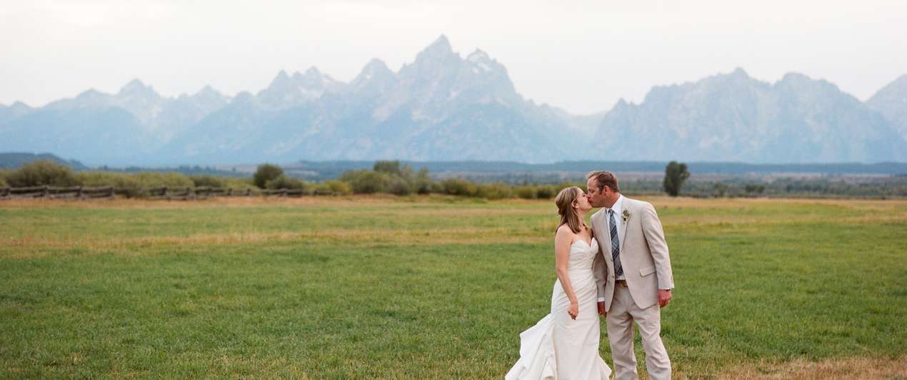 Bride and groom celebrate wedding in front of Grand Tetons